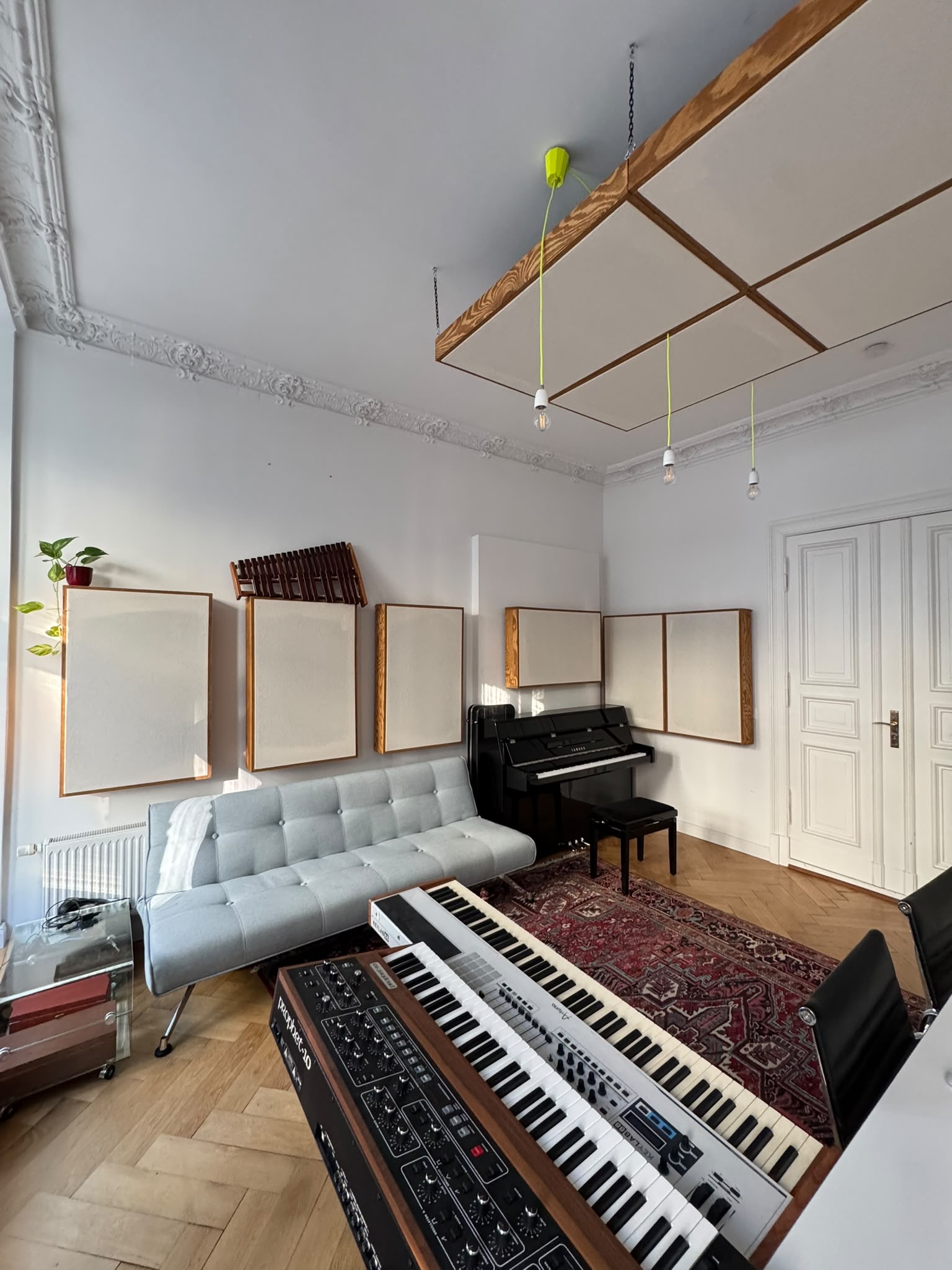 Studio room with sofa, upright piano and keyboards
